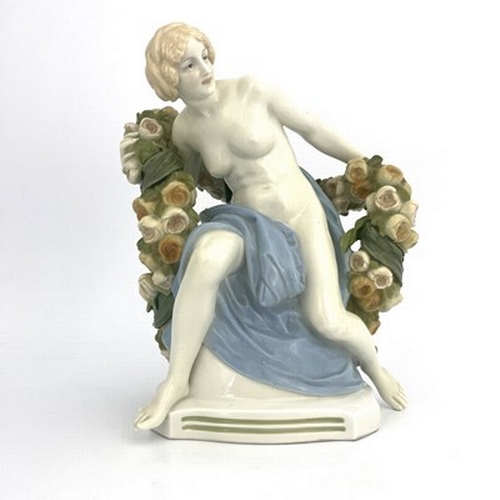 827 - Paul Schley for KPM, an Art Deco female nude figure, modelled seated with a garland of roses, impres... 