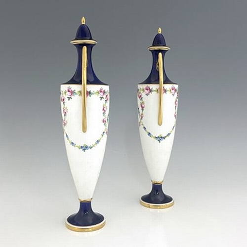 898 - A pair of Minton vases and covers, pedestal twin handled urn form, painted with garlands of roses, p... 