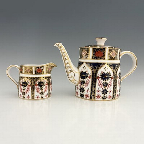 925 - A Royal Crown Derby Imari 1128 teapot and jug, 1968, oval section ogee form, 28cm long (2)