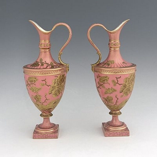 931 - A pair of Royal Crown Derby pink ground and gilt Derby Ewers, 1886, painted in the Aesthetic style w... 