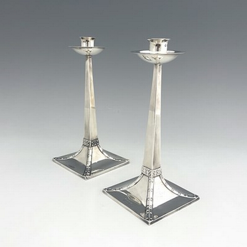 94 - After Jan Eisenloeffel, a pair of Arts and Crafts silver candlesticks, James Ramsay/James Dixon, She... 