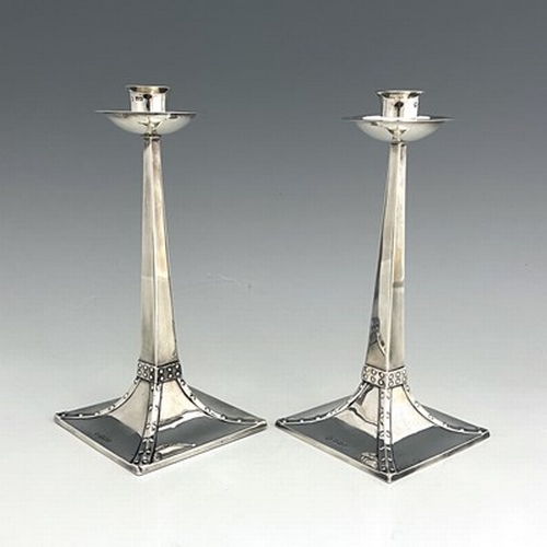 94 - After Jan Eisenloeffel, a pair of Arts and Crafts silver candlesticks, James Ramsay/James Dixon, She... 