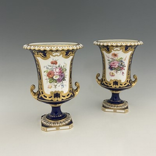 941 - Albert Gregory for Roal Crown Derby, a pair of twin handled Campana Urn vases, 1920, painted with fl... 