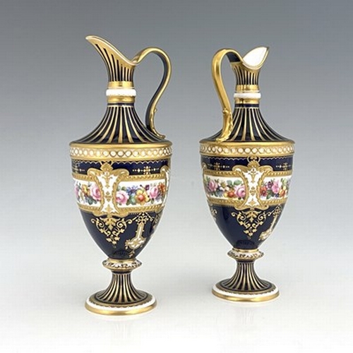 942 - Albert Gregory for Royal Crown Derby, a pair of floral painted ewers, shouldered urn form, decorated... 