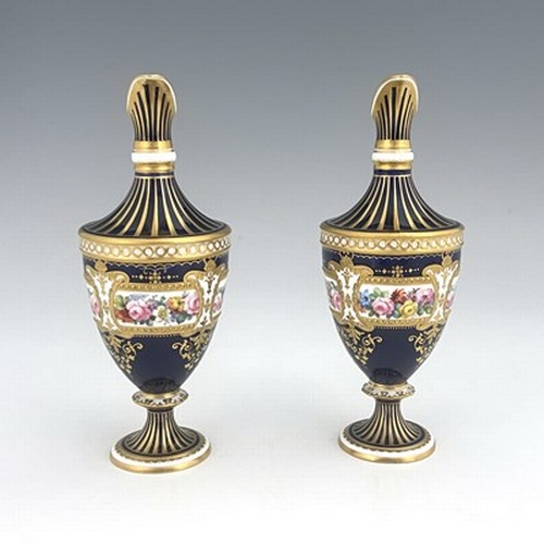 942 - Albert Gregory for Royal Crown Derby, a pair of floral painted ewers, shouldered urn form, decorated... 