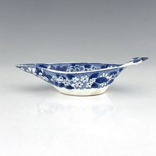 959 - A pearlware blue and white pap boat, circa 1800, relief moulded shell handle, decorated with gardene... 