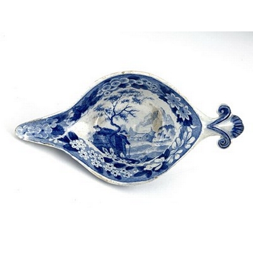 959 - A pearlware blue and white pap boat, circa 1800, relief moulded shell handle, decorated with gardene... 