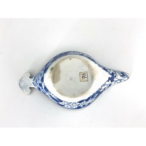 959 - A pearlware blue and white pap boat, circa 1800, relief moulded shell handle, decorated with gardene... 