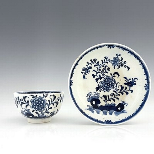 963 - A Lowestoft blue and white porcelain tea bowl and saucer, circa 1770, painted in the Peony and Holed... 