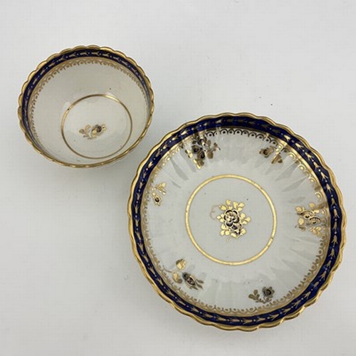 975 - A Caughley tea bowl and saucer, blue S mark, circa 1780, reeded and fluted, with blue and gilt flora... 