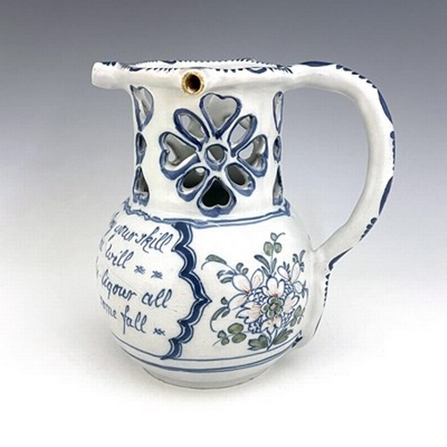 996 - A Liverpool Delft puzzle jug, bulbous form with reticulated neck, blue and white painted with polych... 