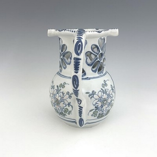 996 - A Liverpool Delft puzzle jug, bulbous form with reticulated neck, blue and white painted with polych... 