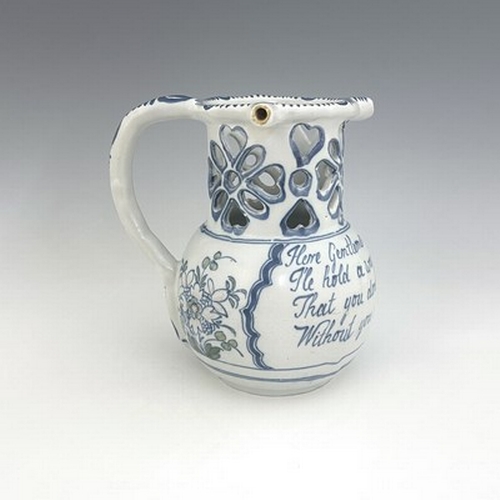 996 - A Liverpool Delft puzzle jug, bulbous form with reticulated neck, blue and white painted with polych... 