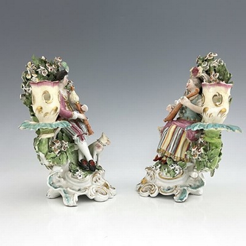 997 - A pair of Derby porcelain shepherd and shepherdess figural candlesticks, circa 1770, bocage backed, ... 