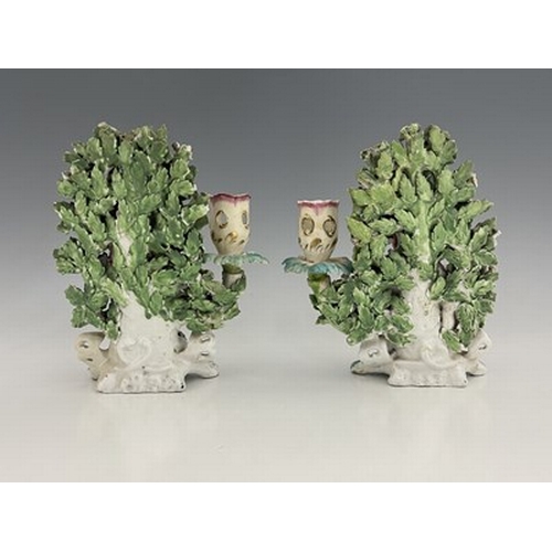 997 - A pair of Derby porcelain shepherd and shepherdess figural candlesticks, circa 1770, bocage backed, ... 