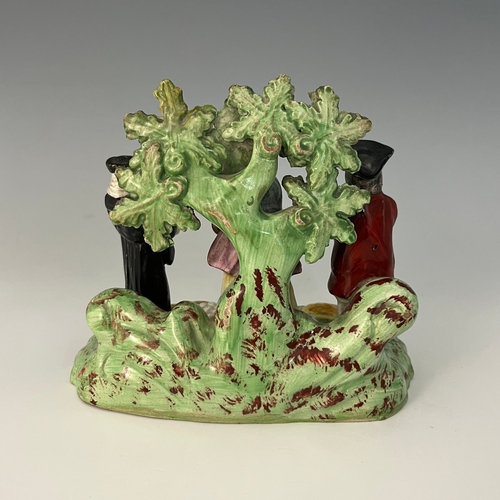 1046 - A Staffordshire 'Tythe Pig' figure group, circa 1820, modelled with three figures beneath flowering ... 