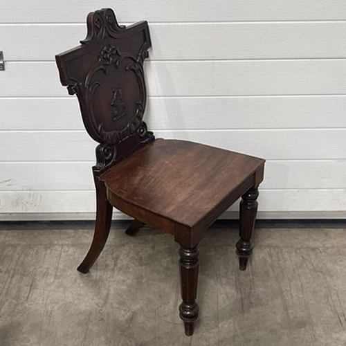 1024 - A 19th Century mahogany hall chair, heraldic back, with turned and sabre supports