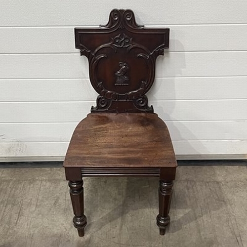 1024 - A 19th Century mahogany hall chair, heraldic back, with turned and sabre supports