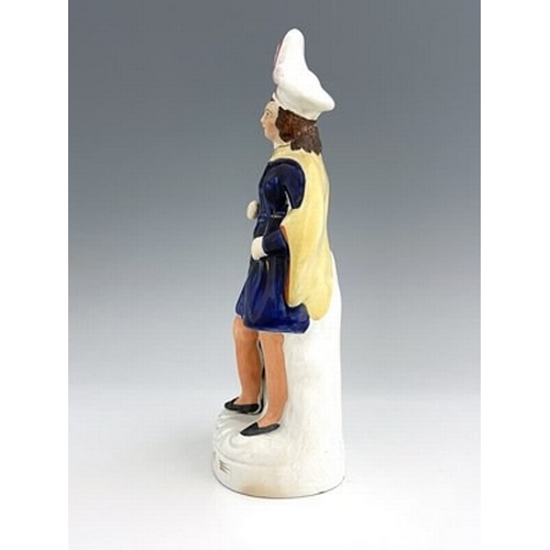 141 - A Staffordshire figure of William Tell and his son, circa 1860, modelled as a flamboyantly dressed m... 