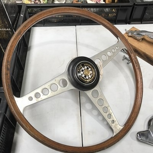 34 - A Jaguar E-Type steering wheel, a Jaguar left nearside wheel nut, two mascots and a desk blotter (5)