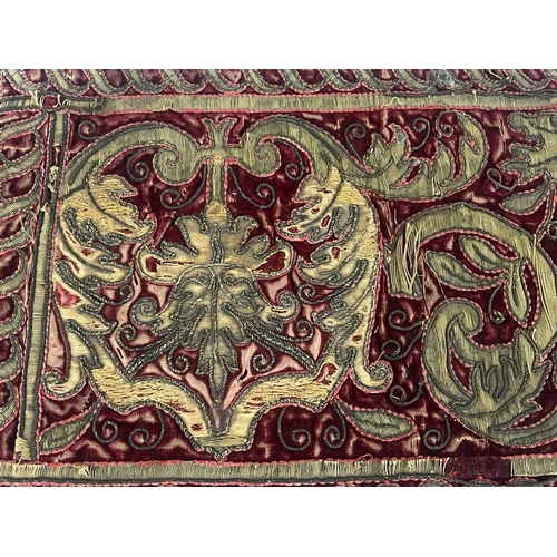 282 - A 17th century gilt embroidered velvet religious hanging, red ground with foliate scroll and acanthu... 