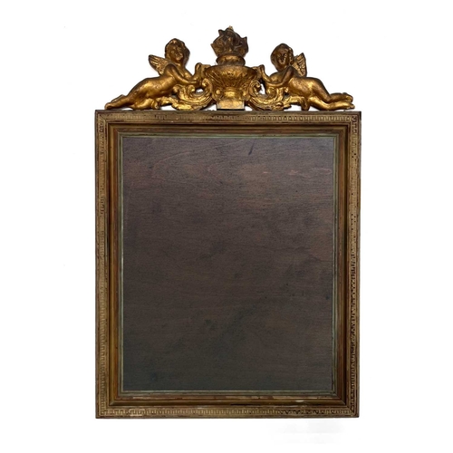 323 - An 18th Century carved gilt wood picture frame, the pediment in the form of two winged cherubs besid... 