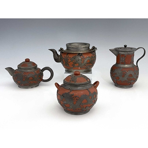 359 - A Chinese Yixing four piece tea set, pewter overlaid redware, chased dragon design below Chinese cha... 