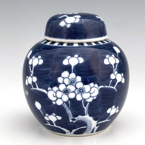 365 - A Chinese blue and white ginger jar and cover, painted with prunus blossom on a blue wavy ground, co... 