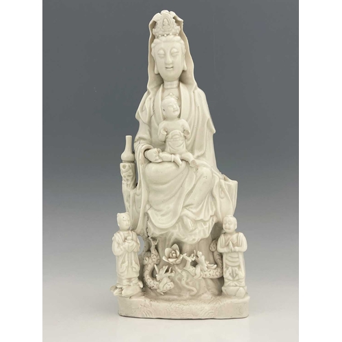 381 - A Chinese blanc de Chine figure of Guanyin, modelled with child on its knee, two further figues and ... 