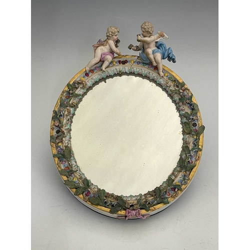 595 - A Meissen figural and florally encrusted mirror frame, oval form, acanthus lappet and foliate border... 