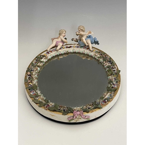 595 - A Meissen figural and florally encrusted mirror frame, oval form, acanthus lappet and foliate border... 