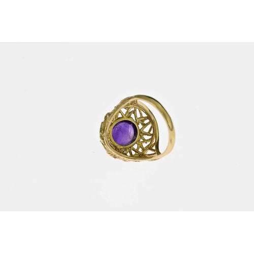 60 - A Modernist 9 carat gold and amethyst cabochon ring, the oval stone in a bark textured nest of knott... 