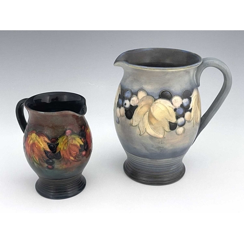 604 - William Moorcroft, a Leaf and Berry jug, circa 1925, blue matt glaze, together with a small Flambe L... 