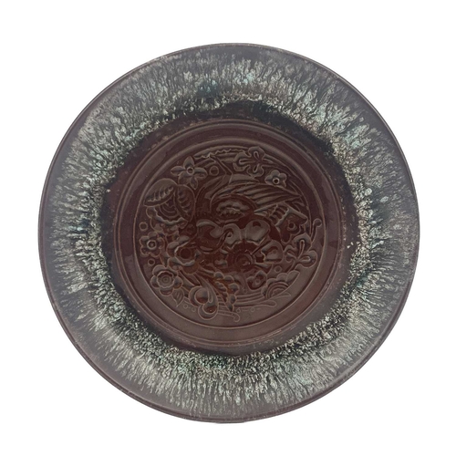 615 - Christopher Dresser for Linthorpe, an art pottery plate, dust pressed in relief with a bird and foli... 