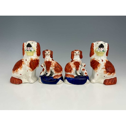 728 - Two pairs of Staffordshire dog figures, one pair modelled as spaniels holding floral baskets, the ot... 