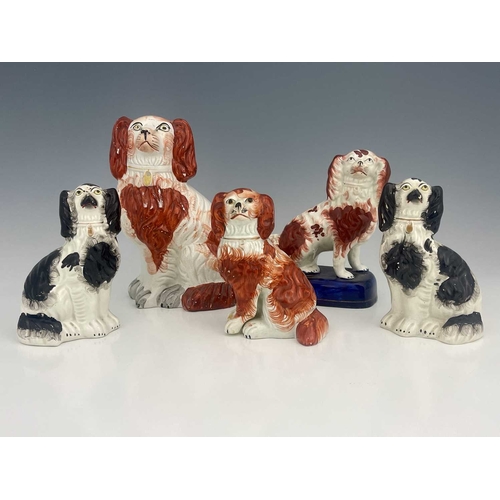 731 - A collection of Staffordshire dog figures, 19th century, including a pair of black spotted spaniels,... 