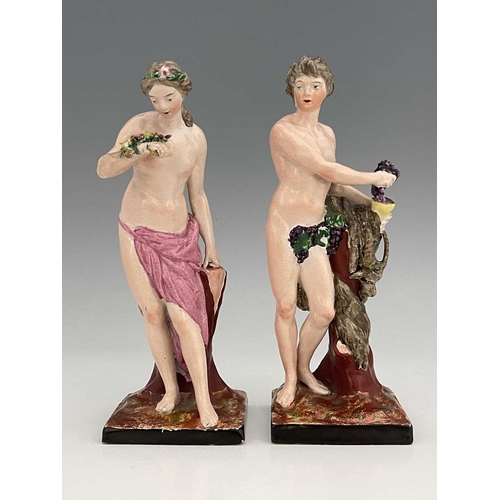 738 - A pair of Staffordshire pottery figures of Ariadne and Dionysus, modelled semi nude standing next to... 