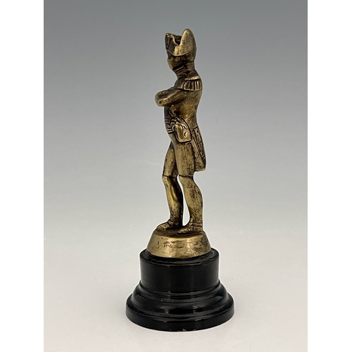 257A - A cast brass figure of Napoleon, modelled standing, on turned ebonised base, 16cm high