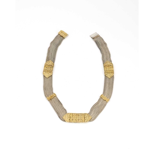 24 - A Middle Eastern silver and parcel gilt choker necklace, nine chain mesh strands united by tooled gi... 