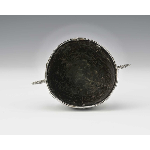 56 - An 18th century Spanish Colonial 'coco chocolatero' white metal mounted chocolate cup, the coconut b... 