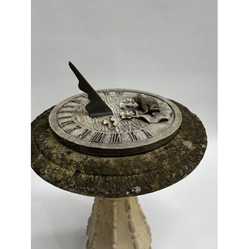 1003 - A sandstone composite birdbath with Roman numerals dial and front figurine, measuring 81.5cm high an... 