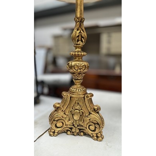 120 - An ornate gold painted metal neoclassical form lamp, featuring claw feet, acanthus scroll legs, and ... 