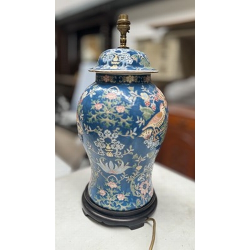 122 - A ceramic baluster form lamp base on a wooden stand, enamel painted on a blue ground in Morris Stra... 