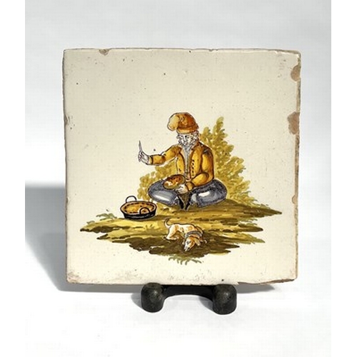 152 - An 18th century Quimper style Spanish tile, depicting a man with his dog, glazed, 20.5cm square, wit... 