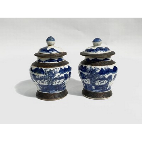 212 - A pair of 19th-century blue and white Chinese jars with lids, featuring mountainous scenery, 15cm hi... 