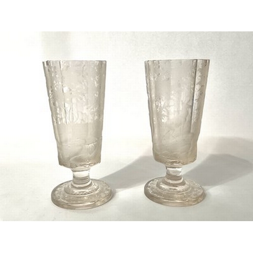 256 - A pair of Bohemian intaglio engraved glass stag beakers, pedestal footed form, octagonal section, de... 