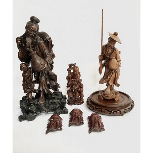 277 - A collection of Chinese, hardwood figureines with miniature facemasks, circa 20th century, tallest a... 