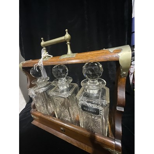 278 - A brass bound, 19th century lockable tantalus decanter set complete with key and cut glass decanters... 