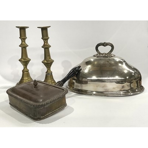 63 - A pair of brass candlesticks, along with a copper silent butlerand, two platter silver plate lids an... 