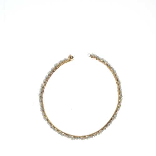 128 - An 18ct gold seed pearl bangle bracelet, with pin clasp, inner diameter 6.1cm, 10.6g